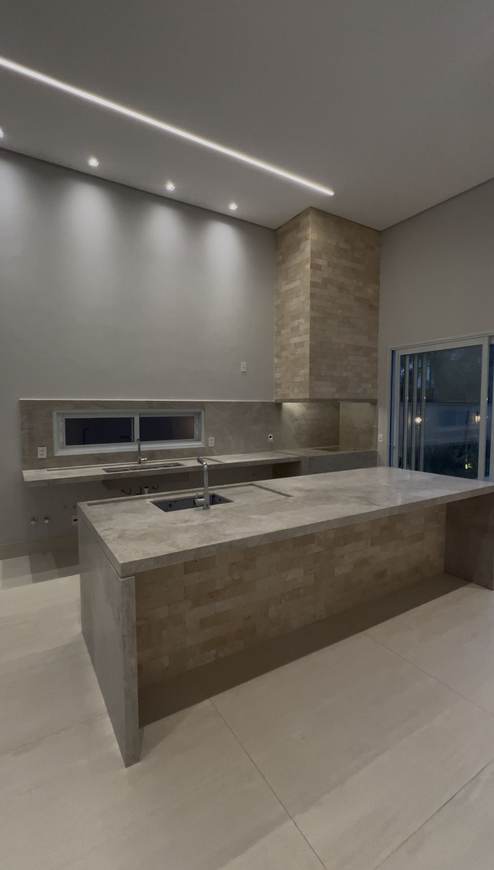 Cozinha gourmet com ilha revestida em pedra